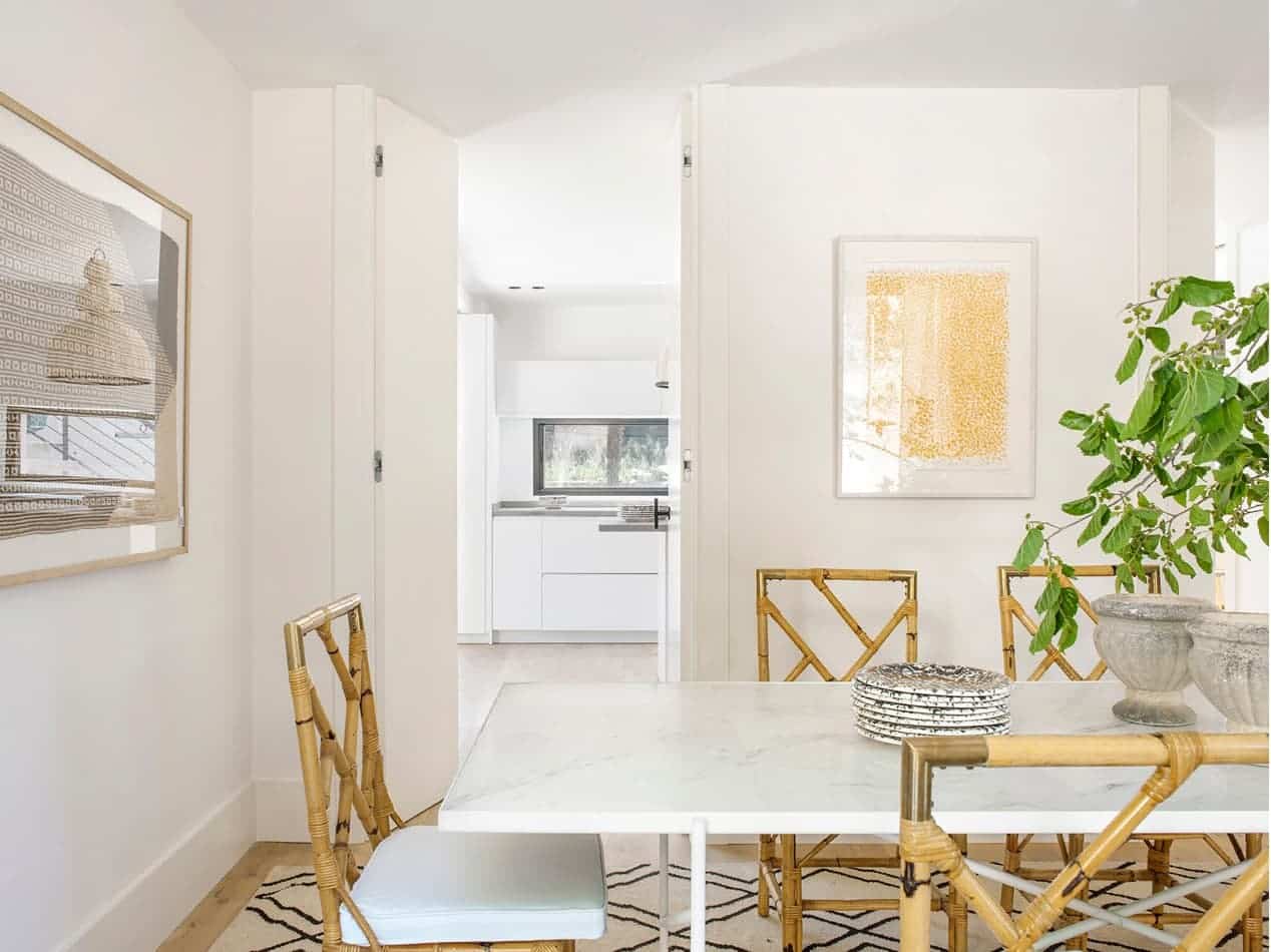 Estudio María Santos Reforma integral y decoración de vivienda minimalista Madrid comedor con mesa blanca y silla de mimbre