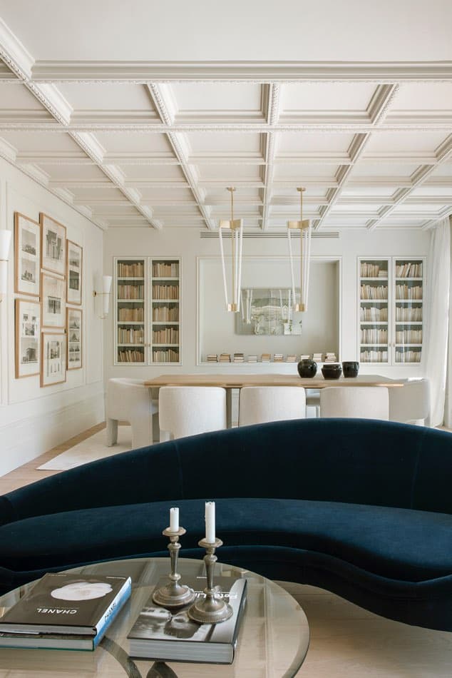 Estudio Maria Santos Reforma integral y decoración en Madrid salón minimalista en tonos blancos con sofá de diseño italiano de ico parisi de terciopelo azul